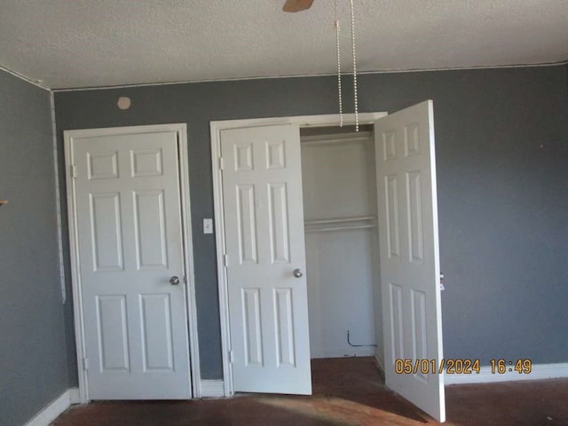 unfurnished bedroom with ceiling fan and a textured ceiling