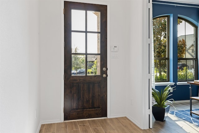 doorway to outside featuring baseboards and wood tiled floor