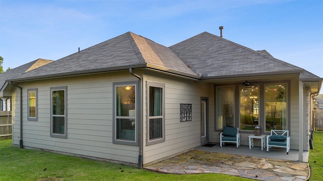 back of house with a patio area, a shingled roof, fence, and a yard