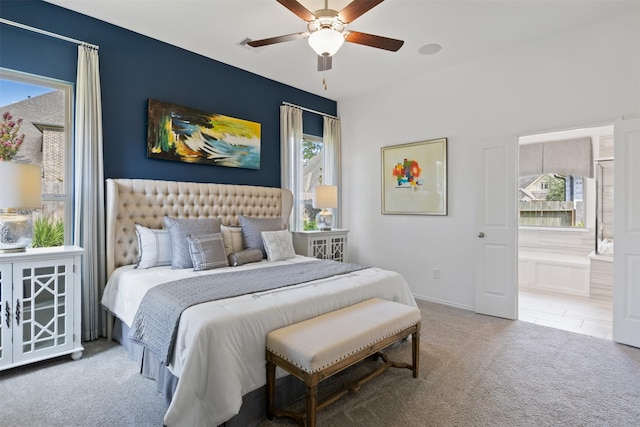 bedroom featuring carpet floors, ensuite bath, and a ceiling fan