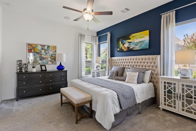 carpeted bedroom featuring ceiling fan and visible vents