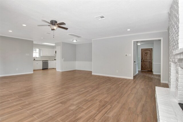 427 Pebblebrook Dr, El Lago, TX 77586 - unfurnished living room with light hardwood / wood-style floors, a fireplace, ceiling fan, ornamental molding, and sink