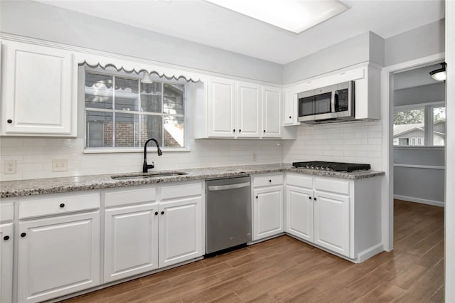 427 Pebblebrook Dr, El Lago, TX 77586 - kitchen featuring backsplash, appliances with stainless steel finishes, hardwood / wood-style flooring, and white cabinets