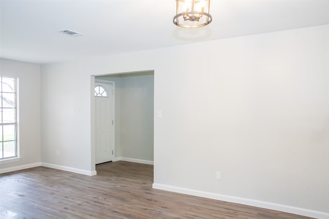 unfurnished room featuring hardwood / wood-style flooring and a notable chandelier