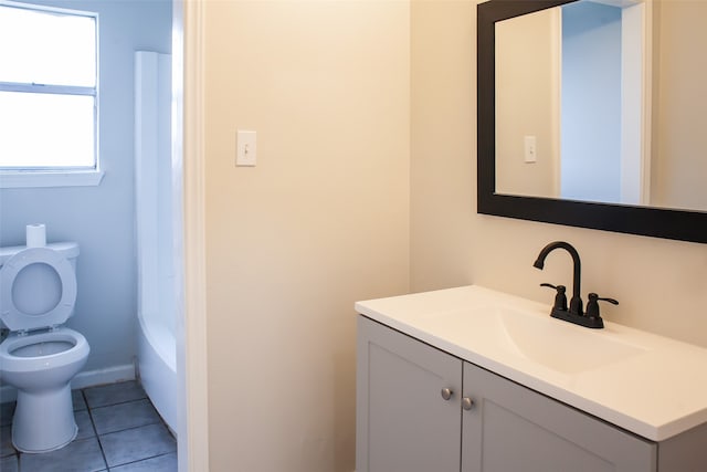 bathroom with tile flooring, vanity with extensive cabinet space, and toilet