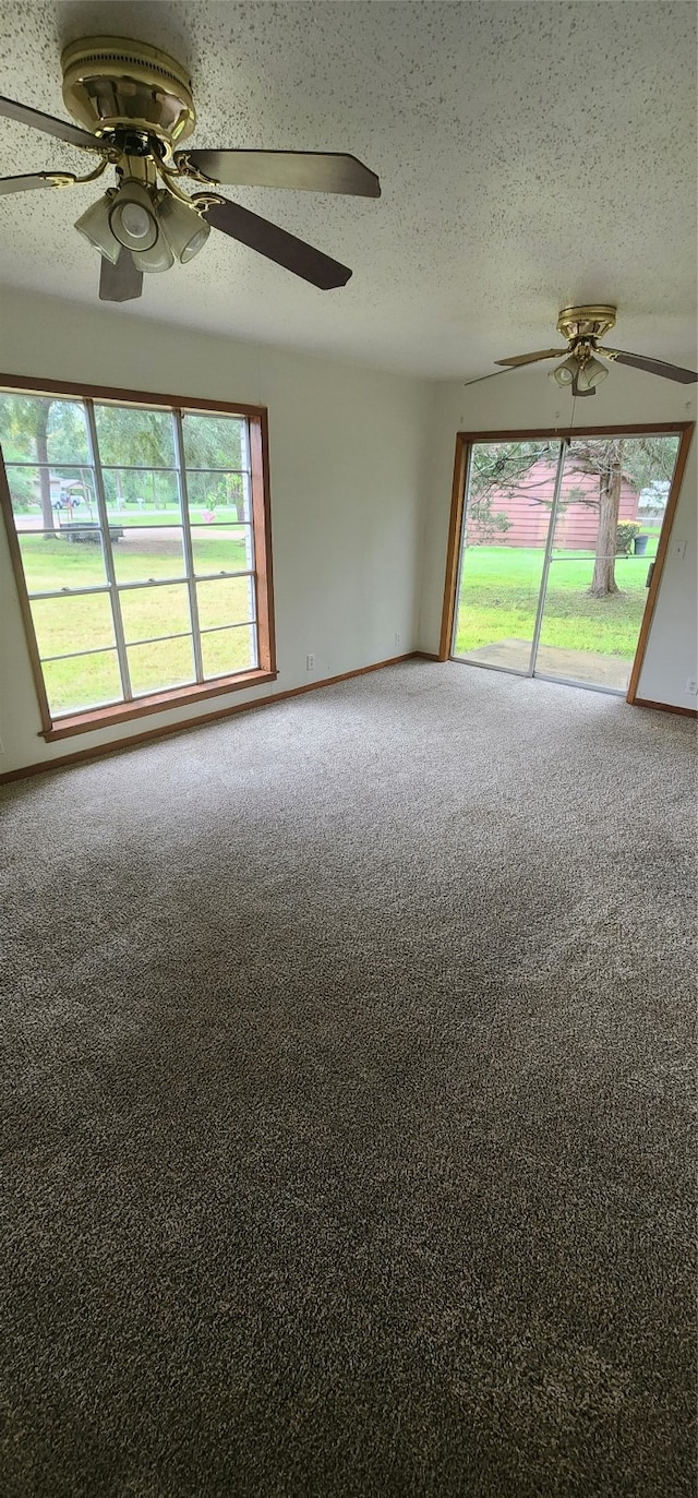 carpeted spare room with ceiling fan and a textured ceiling