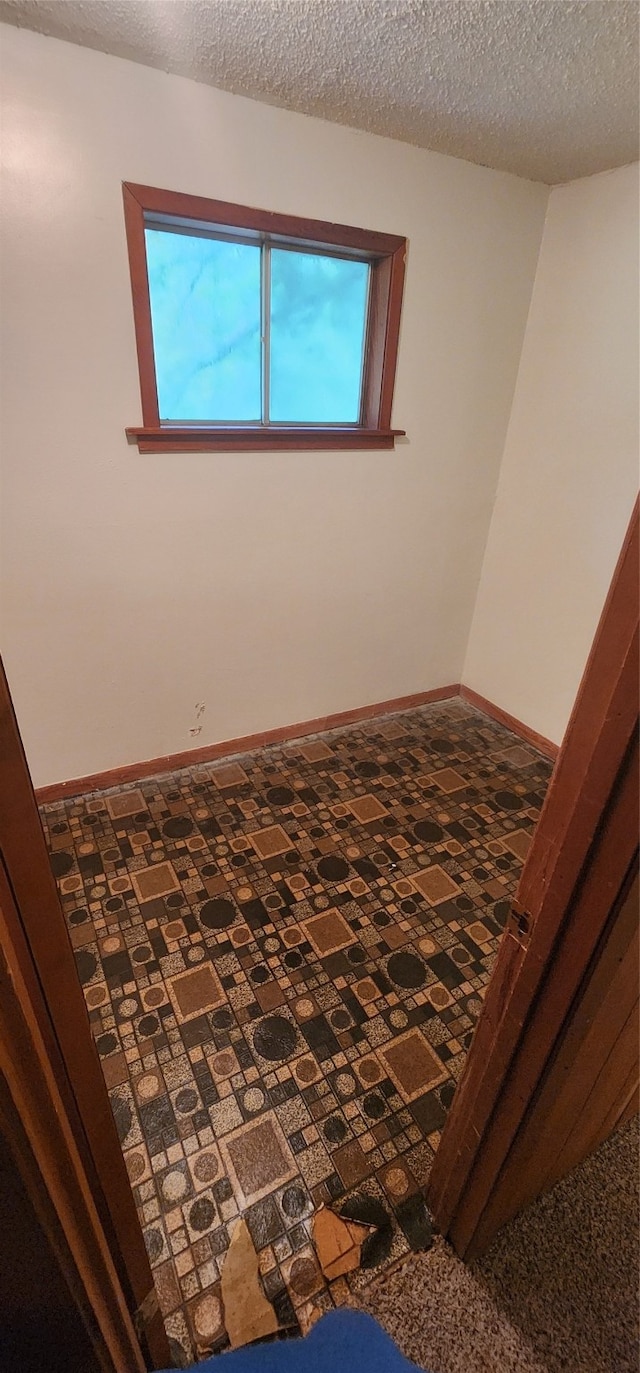 unfurnished room with a textured ceiling