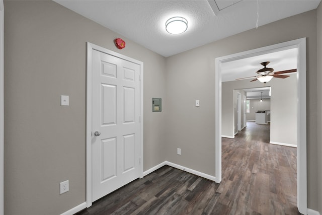 hall featuring a textured ceiling and dark hardwood / wood-style floors