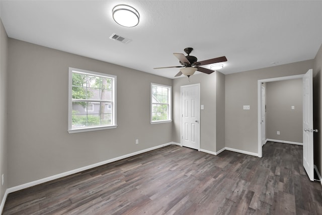 unfurnished bedroom with ceiling fan, a closet, and dark wood-type flooring