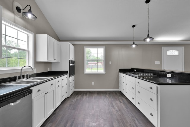 kitchen featuring dark hardwood / wood-style flooring, appliances with stainless steel finishes, white cabinets, pendant lighting, and sink