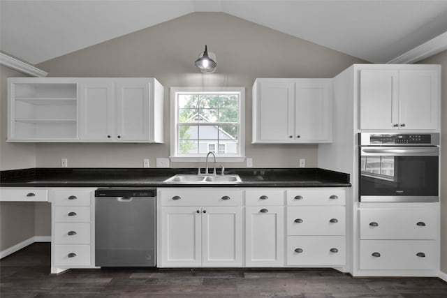 kitchen with appliances with stainless steel finishes, sink, vaulted ceiling, and dark hardwood / wood-style flooring