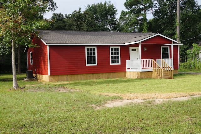 view of front of property with a front yard and central AC unit