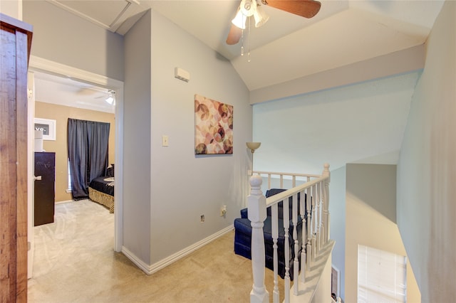 hallway featuring vaulted ceiling and light carpet