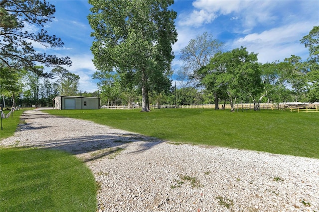 view of yard with an outdoor structure, a rural view, and a garage