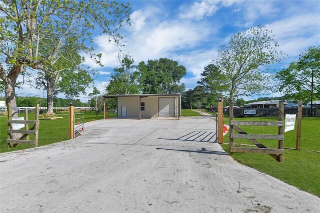 view of front of property with a front yard, an outdoor structure, and a garage