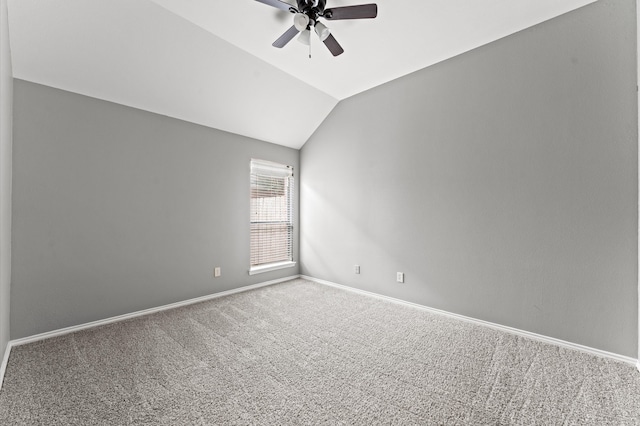 empty room with lofted ceiling, ceiling fan, and carpet