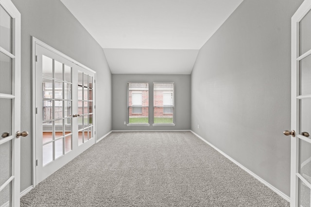 empty room with french doors, vaulted ceiling, and carpet