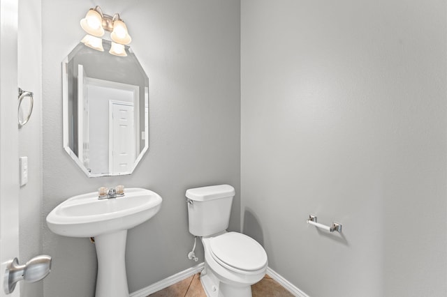 bathroom featuring tile flooring and toilet