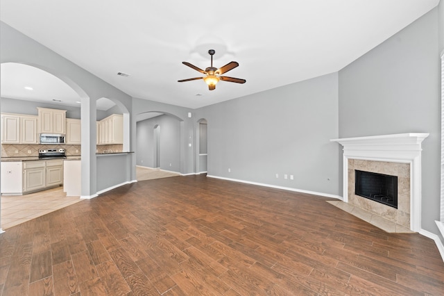 unfurnished living room featuring a fireplace, hardwood / wood-style floors, and ceiling fan