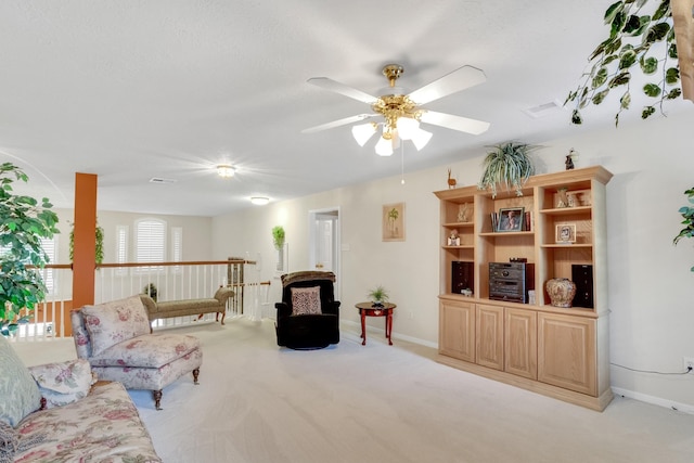 sitting room with baseboards, a ceiling fan, and light colored carpet