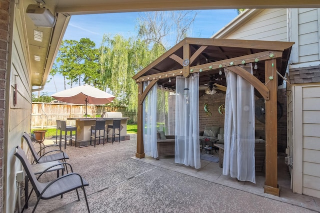 view of patio featuring outdoor dry bar and fence