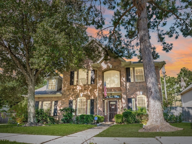 view of front of property with a yard and brick siding