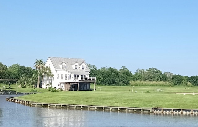 back of house with a water view and a yard