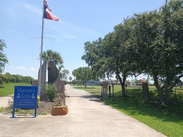 view of home's community with a gate, fence, and a lawn