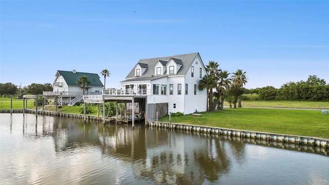 back of property featuring a water view and a yard