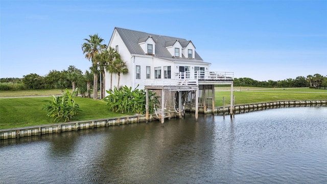 exterior space featuring a deck with water view and a yard