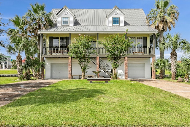 raised beach house with brick siding, concrete driveway, an attached garage, a front yard, and metal roof