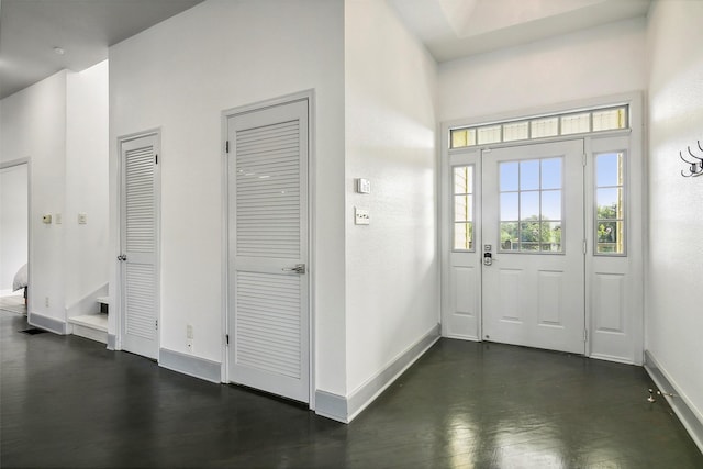 foyer featuring dark wood finished floors and baseboards