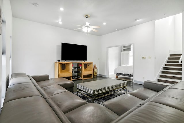 living room featuring ceiling fan and concrete flooring