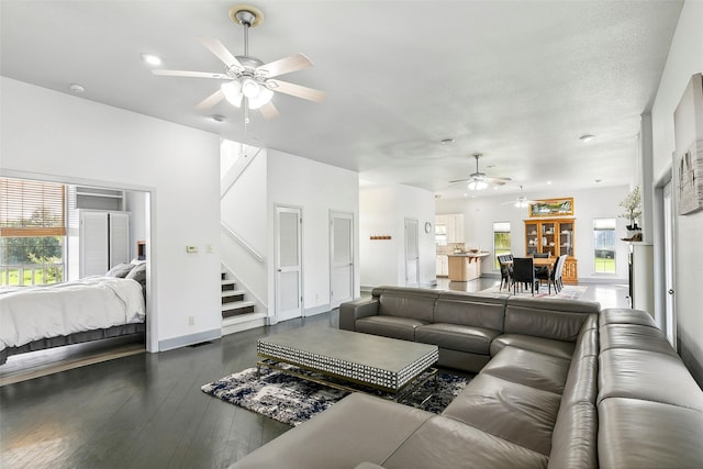 living room with a ceiling fan, baseboards, stairway, and wood finished floors