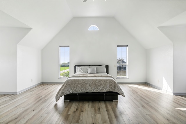 bedroom featuring ceiling fan, light wood-type flooring, and lofted ceiling