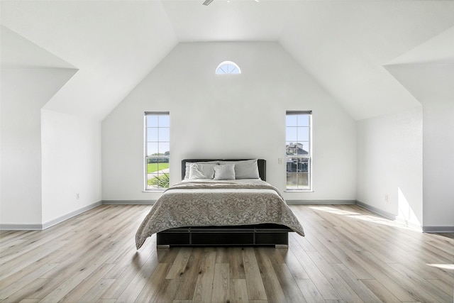 bedroom with lofted ceiling, wood finished floors, and baseboards