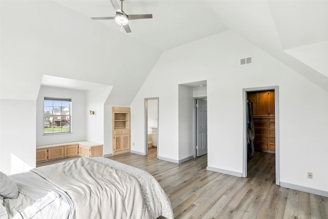 bedroom with ensuite bathroom, ceiling fan, a closet, vaulted ceiling, and a walk in closet