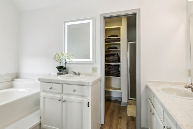 bathroom with shower with separate bathtub, hardwood / wood-style flooring, and vanity