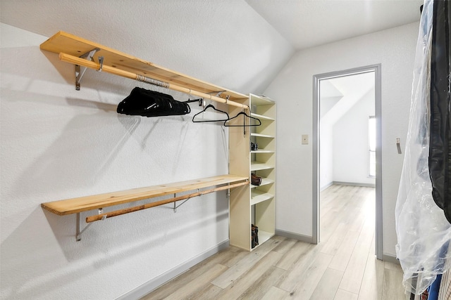 spacious closet featuring lofted ceiling and light wood finished floors