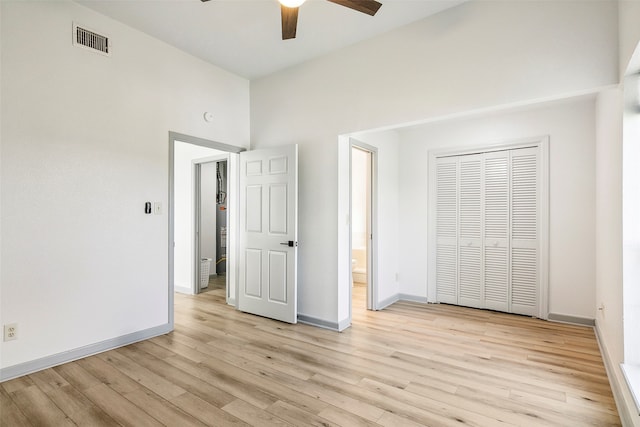 unfurnished bedroom with ceiling fan, light hardwood / wood-style floors, and a closet