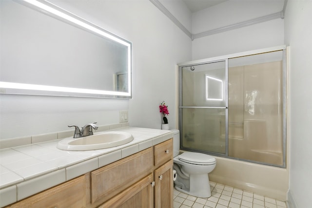 full bathroom with combined bath / shower with glass door, vanity, tile patterned flooring, and toilet