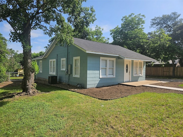 view of front of house with central AC unit and a front lawn