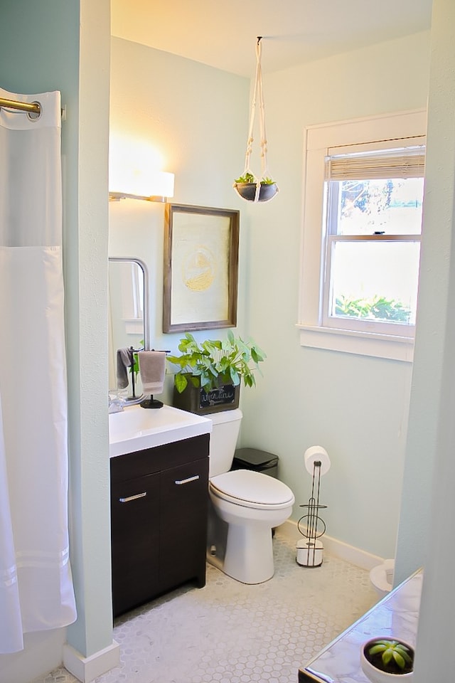 bathroom featuring tile flooring, toilet, and vanity