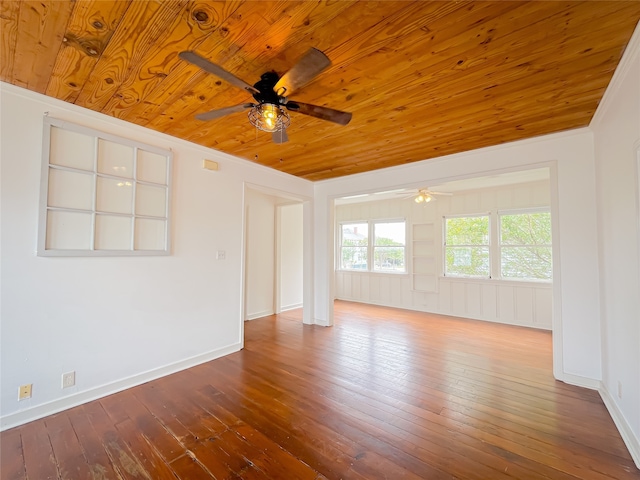 spare room featuring wood-type flooring, ornamental molding, ceiling fan, and wood ceiling