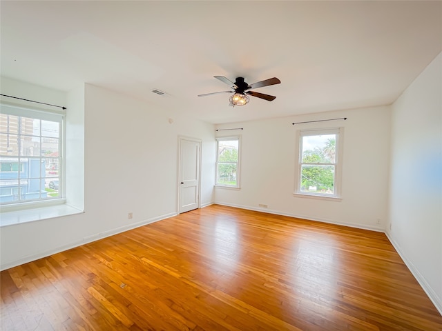 empty room with ceiling fan and hardwood / wood-style floors