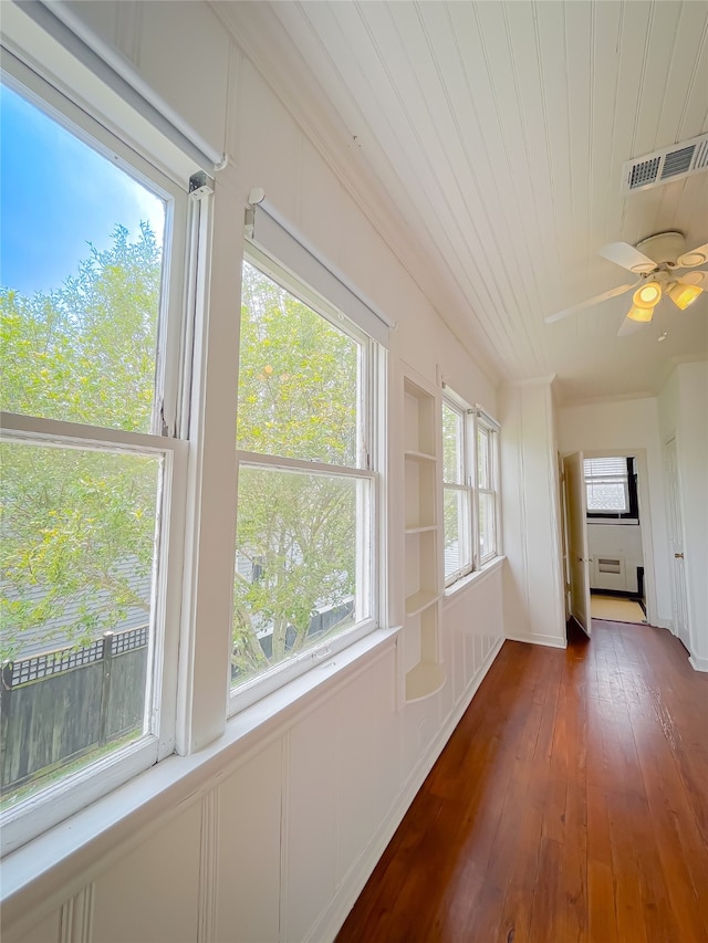 unfurnished sunroom featuring ceiling fan