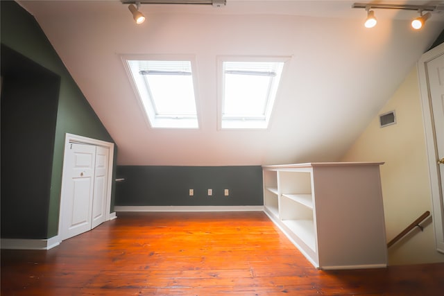 bonus room with vaulted ceiling with skylight and hardwood / wood-style floors