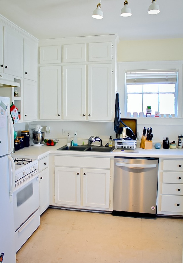 kitchen featuring decorative light fixtures, white cabinetry, sink, white appliances, and premium range hood