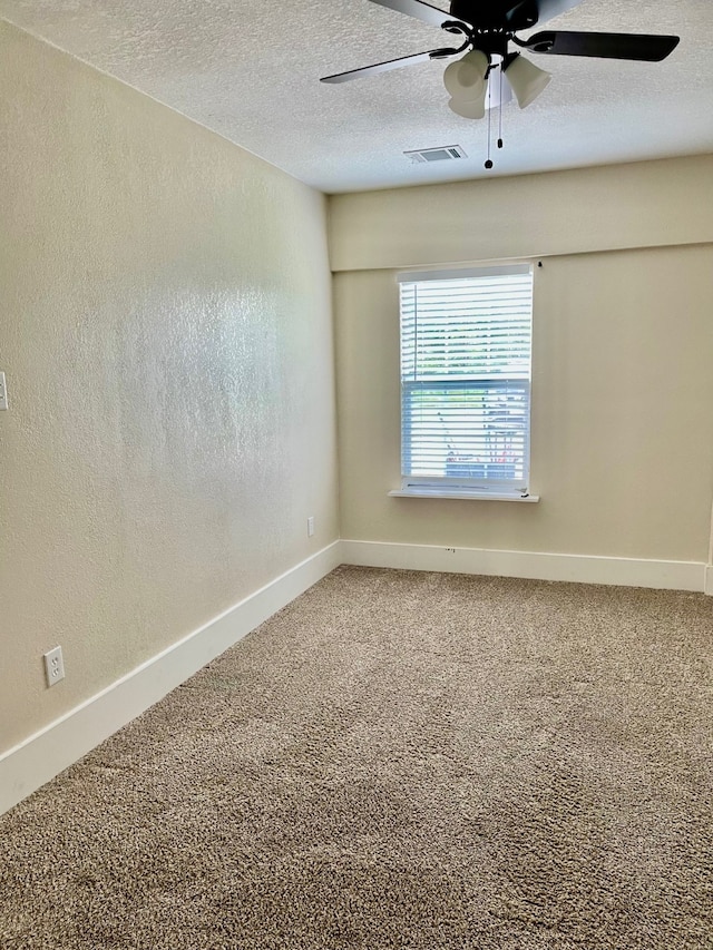 carpeted empty room with ceiling fan and a textured ceiling