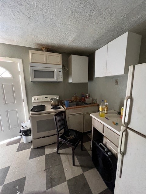 kitchen with light tile flooring, white cabinets, sink, white appliances, and a textured ceiling